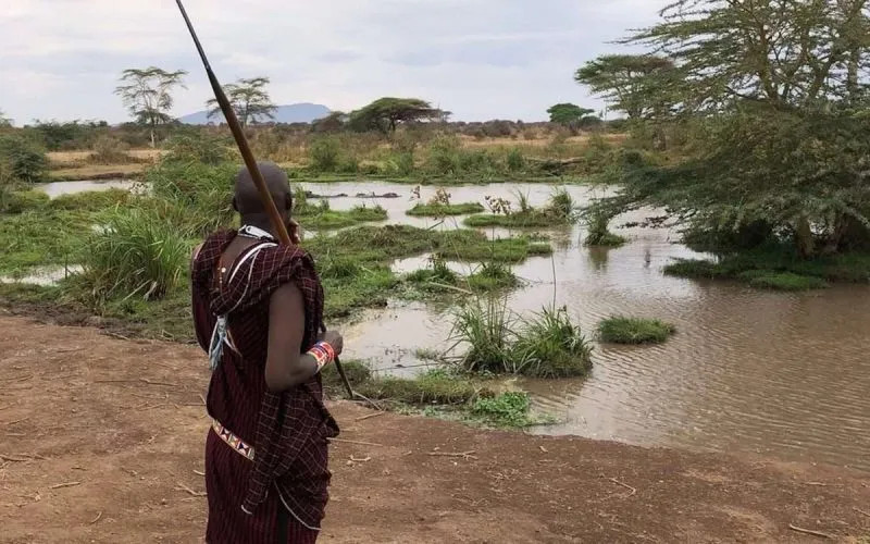 Maasai man with a spear beside a river