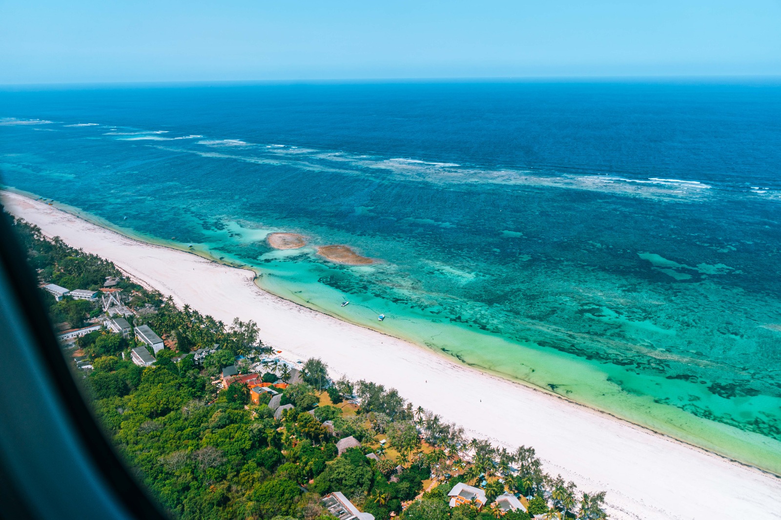 Aerial view of a white sand beach and coral reef