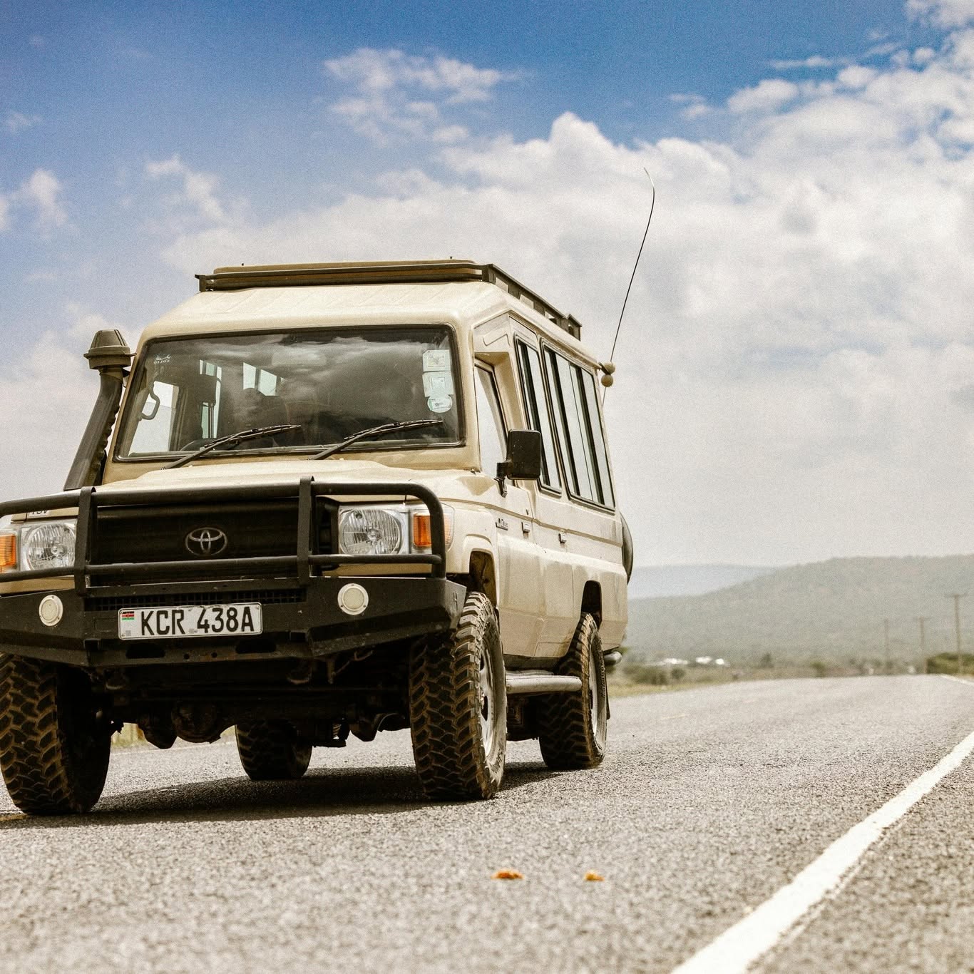 Safari Land Cruiser on a road with a pop-up roof