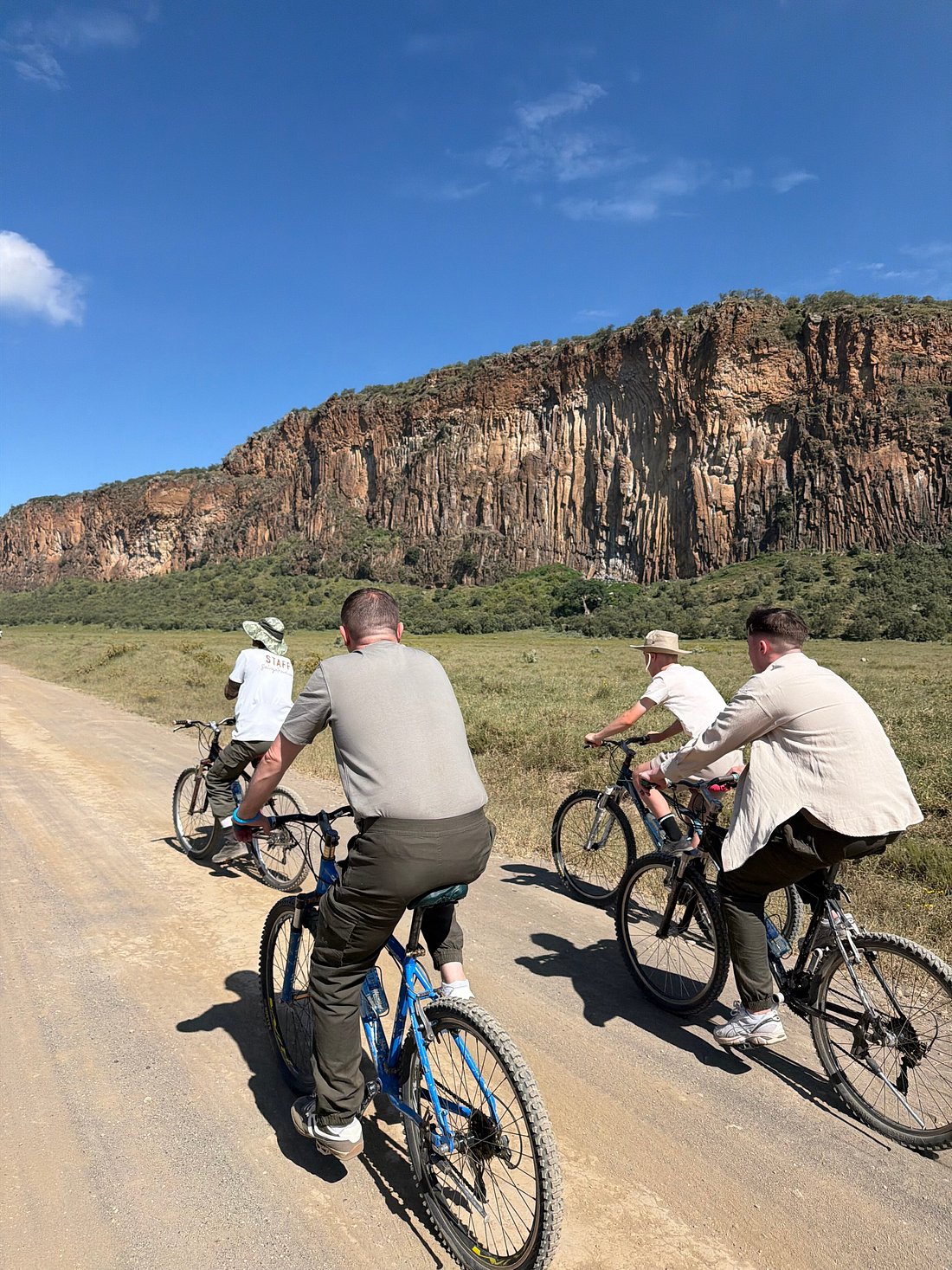 Cyclists riding below the cliffs of Hell's Gate National Park