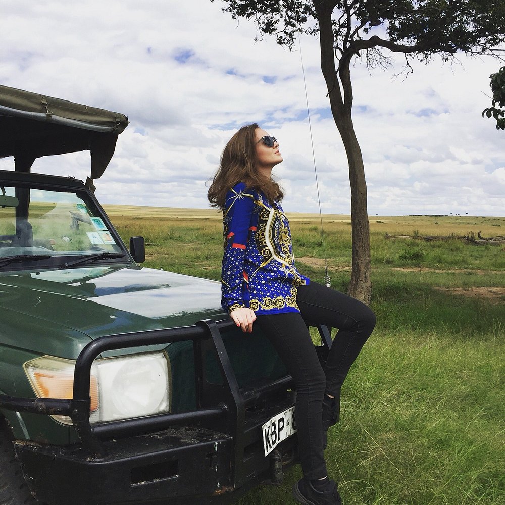 Guest sitting on the bonnet of a safari vehicle
