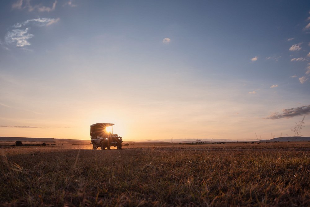 Safari vehicle on the plains at sunrise