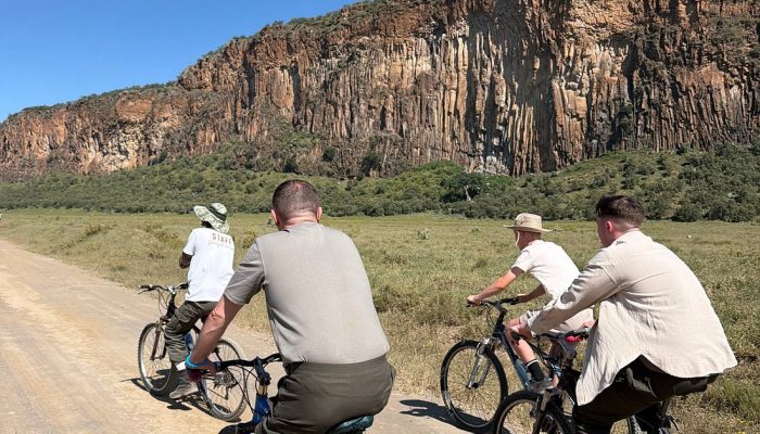 Cyclists riding below the cliffs of Hell's Gate National Park