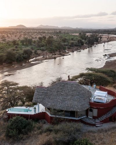 Aerial view of a lodge beside a river in dry country